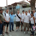 The coaches meet Father Cesar of El Pepeto Parish